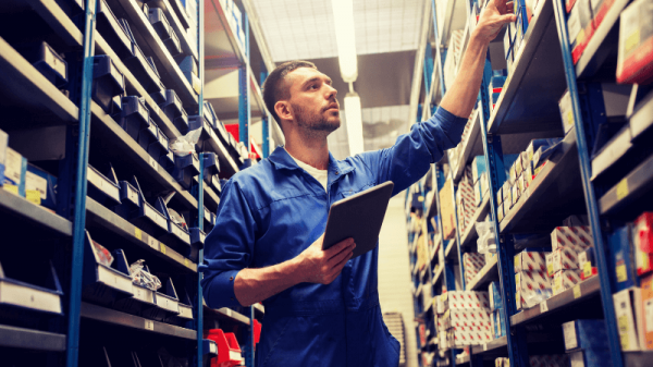 Worker in warehouse with tablet in hand