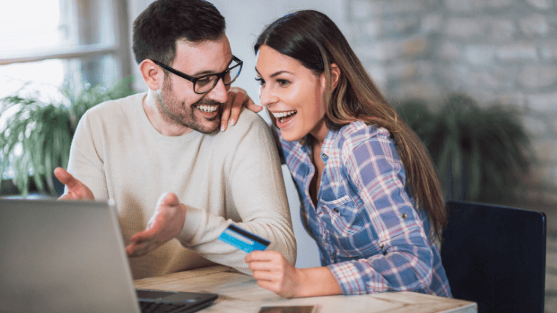 Couple looking at laptop and smiling