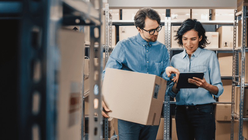 People looking at tablet in warehouse