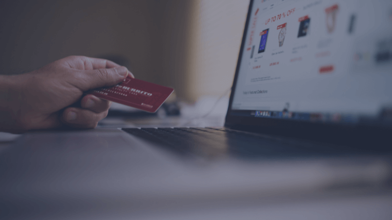 Hand with card and laptop